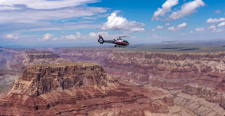 a helicopter flying over a canyon