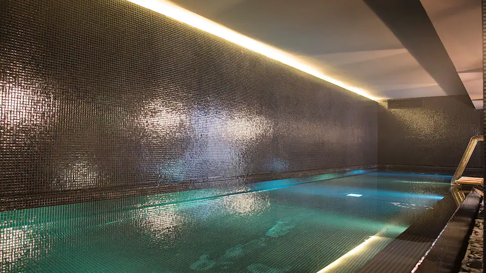 a pool with a wall and lights