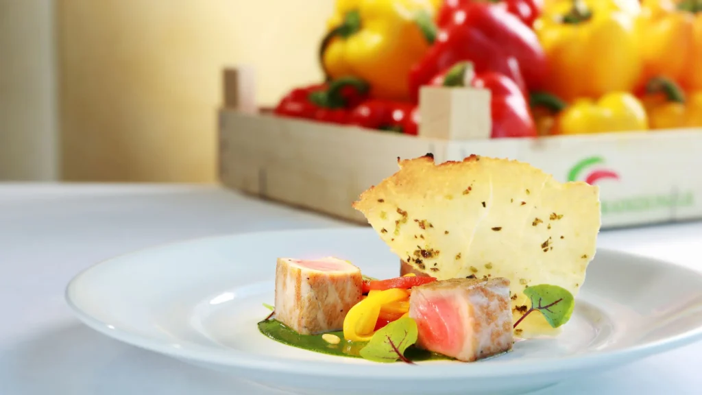 a plate of food with a basket of peppers in the background