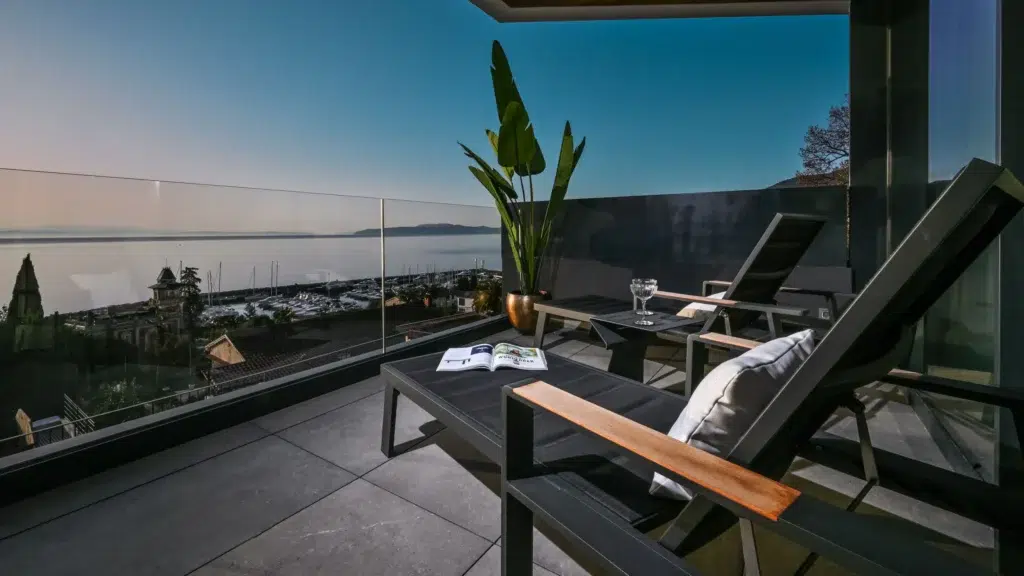 a deck with chairs and a glass railing