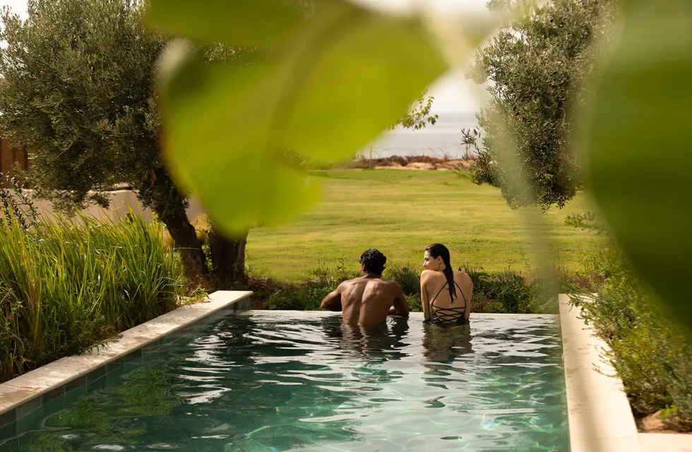 a man and woman sitting in a pool