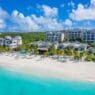 a beach with buildings and palm trees