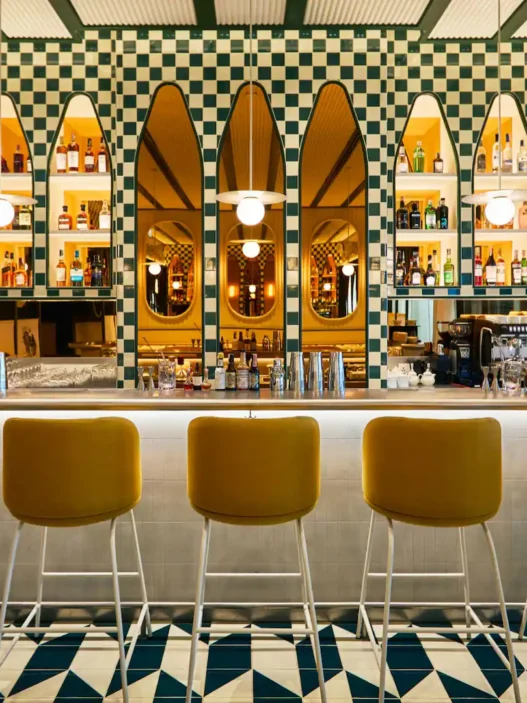a bar with yellow chairs and a white counter