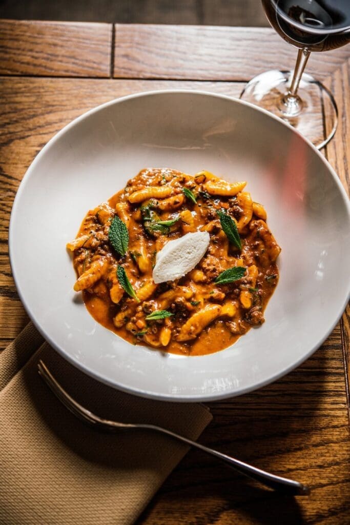 a bowl of pasta with meat and cheese