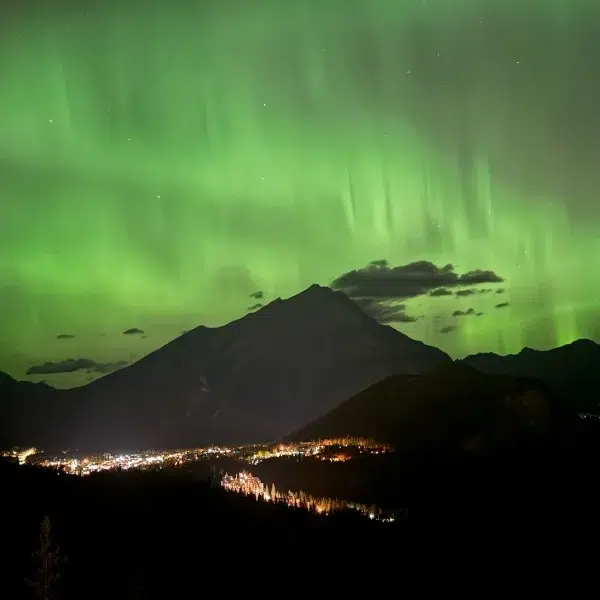 green lights in the sky over a mountain