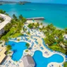 a swimming pool with palm trees and a beach