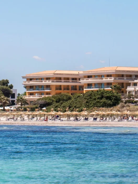 a beach with a building and people on it