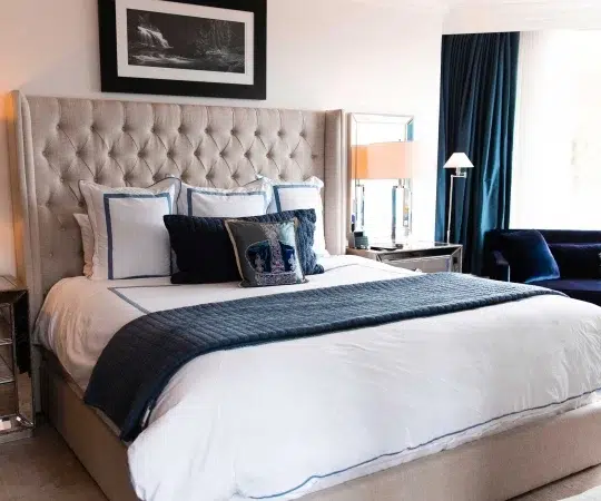a bed with a blue blanket and a blue chair