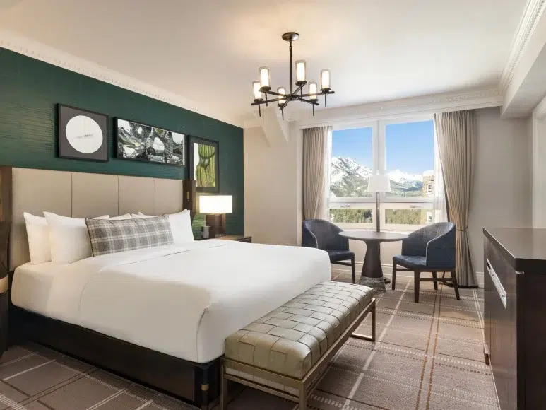 a room with a bed and chairs