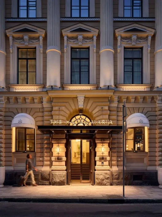 a building with columns and a man walking in front of it