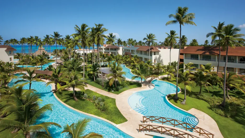 a swimming pool with palm trees and buildings