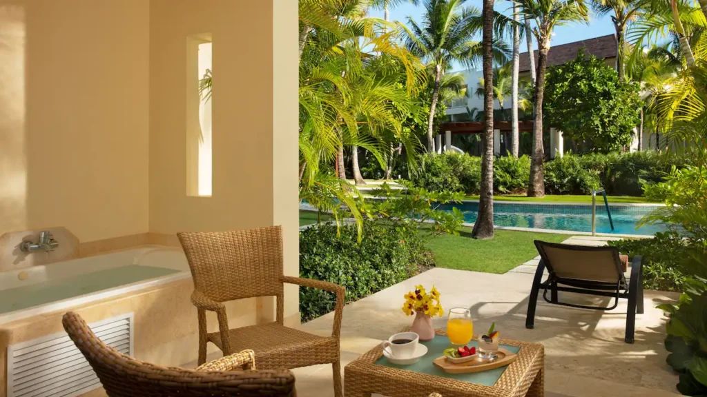 a patio with chairs and a hot tub and a pool