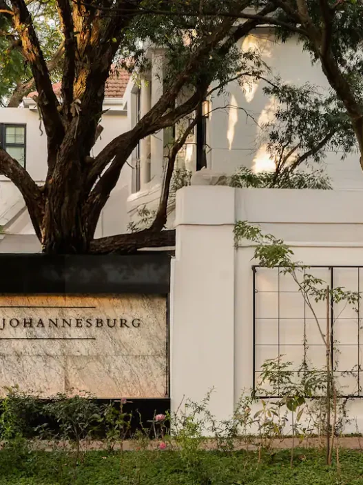 a sign on a wall with trees in the background
