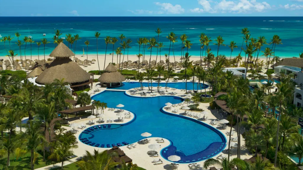 a pool with palm trees and a beach