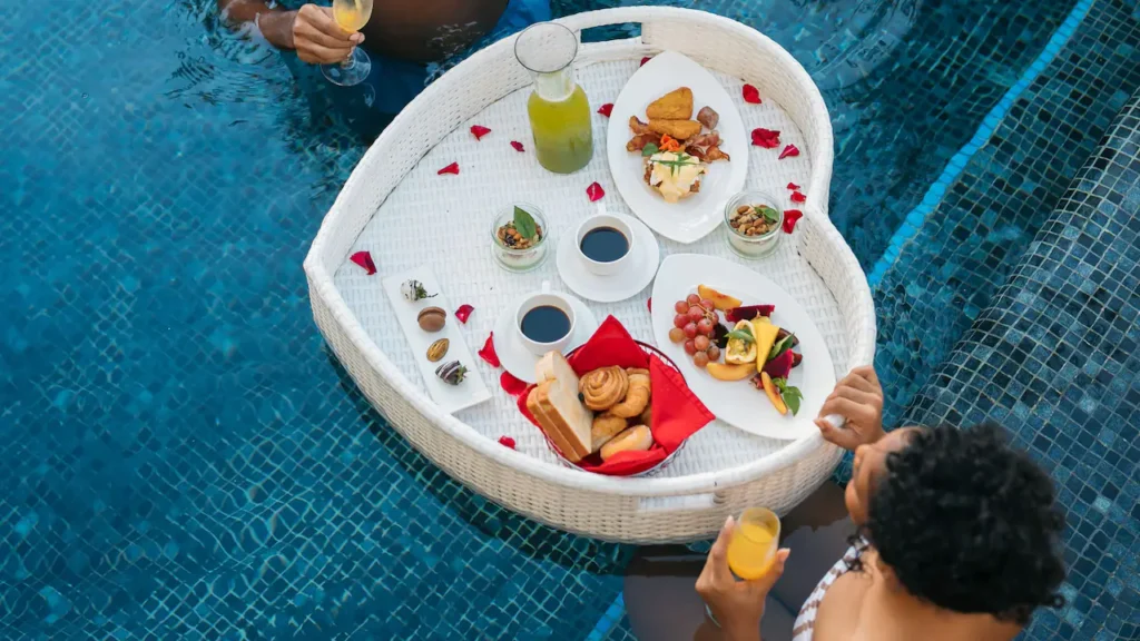 a group of people sitting around a tray of food
