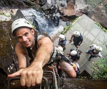 a man wearing a helmet and climbing a ladder