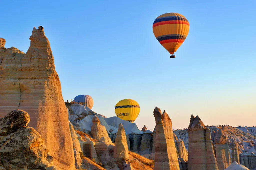 hot air balloons flying over a rocky landscape