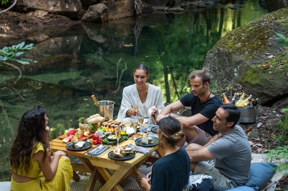 a group of people sitting around a table with food