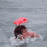 a person swimming in water with a frisbee