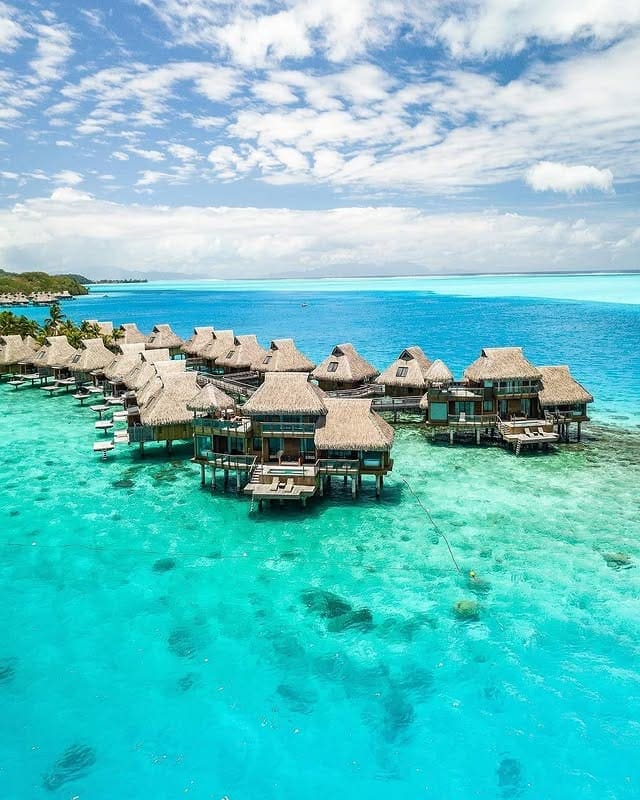 a group of huts on stilts in the water